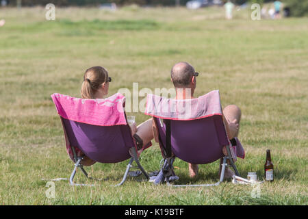 London, UK. 26th Aug, 2017. A couple sitting in chairs enjoying the balmy weather on Wimbledon Common as warmer temperatures are predicted during the August bank holiday weekend Credit: amer ghazzal/Alamy Live News Stock Photo