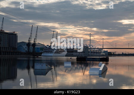 Silvertown, Newham, London, UK. 27th August 2017. UK Weather: Bright Bank holiday sunrise over London Docklands. A warm sunny day is expected. London Victoria dock with Excel exhibition centre and Sunborn Yacht hotel. Credit: WansfordPhoto/Alamy Live News Stock Photo