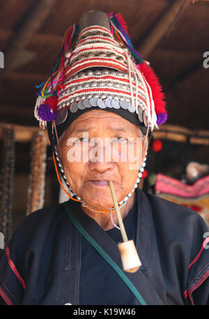 Closeup portrait of old woman a pagan tribe Lisu Smoking a pipe. Stock Photo