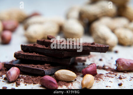 Pile of dark chocolate covered with cocoa powder with peanuts and nutshells Stock Photo