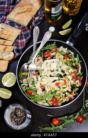 Pasta with crushed olives and cherry tomatoes, arugula. Stock Photo