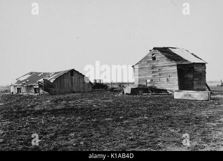 A hay house and corn crib, both in various stages of collapse, situated on the barren land of CV Hibbs' owner operated farm that had been heavily mortgaged, near Boswell, Benton County, Indiana, 1937. From the New York Public Library.