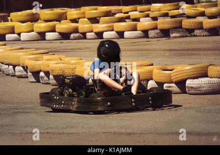 A man is driving Go-kart with speed in the park on karting track - front view. Stock Photo
