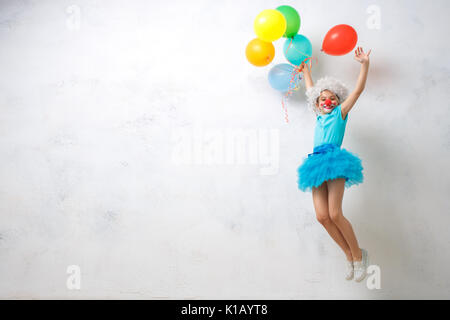 Little child wearing clown costume birthday celebration with balloons Stock Photo