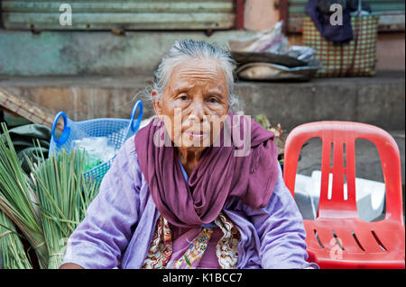 Portrait of an old woman sitting in a Yangon street market Myanmar Stock Photo