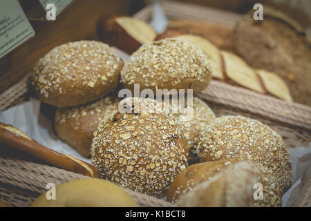 Retro effect faded image with different types of bread in the basket Stock Photo