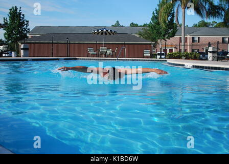 Professional swimmer workout. Athlete's practicing butterfly style in outside swimming pool with blue water color. Concept of power Stock Photo