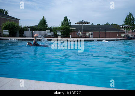 Crowl style of swimming. Professional swimmer training in pool. Athlete workout. Drops of water. Recreation environment at the swimming pool. Stock Photo