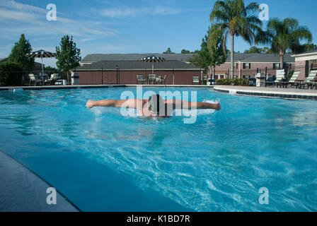 Butterfly style swimming workout. Strong male athlete training. Blue water swimming pool. Stock Photo