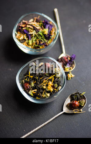 Different types of tea, green tea, peony and ginger tea, rose bud and wild flowers tea on dark wooden background with copyspace Stock Photo