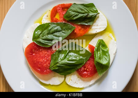 Caprese salad, with mozzarella, tomatoes, basil and olive oil . . . in the colors of the Italian flag Stock Photo