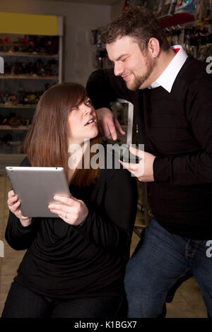 woman and man holding computer tablets, woman looks frustrated or annoyed Stock Photo