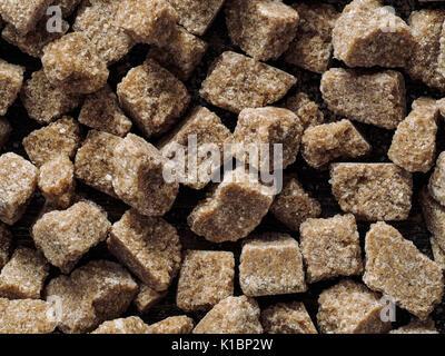 natural raw brown cane sugar cubes close up as background. Top view of brown sugar pattern. Stock Photo