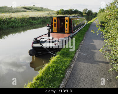 Traditional painted narrowboat in tug style moored in countryside Stock Photo