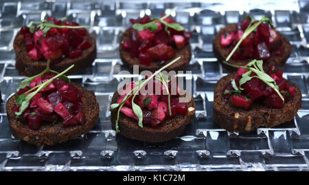 Roasted beet hors d'oeuvres on dark bread with parsley topping Stock Photo