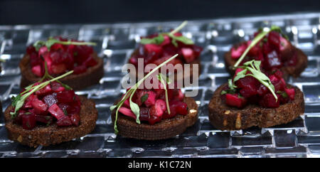 Roasted beet hors d'oeuvres on dark bread with parsley topping Stock Photo