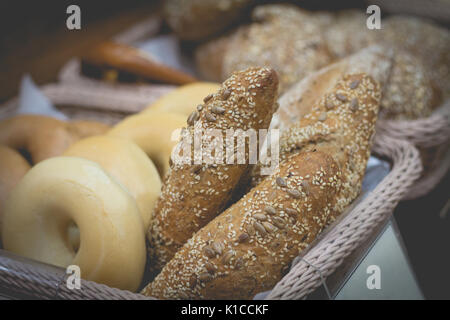 Retro effect faded image with different types of bread in the basket Stock Photo