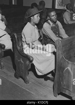Male and female African-American farmers sitting in pews at a church during a Farm Security Administration meeting of borrowers in a church near Woodville, Greene County, Georgia, 1941. From the New York Public Library. Stock Photo
