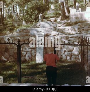 Young child looking at a gravestone in Boot Hill Graveyard, Deadwood, Black Hills, South Dakota, 1975. Stock Photo