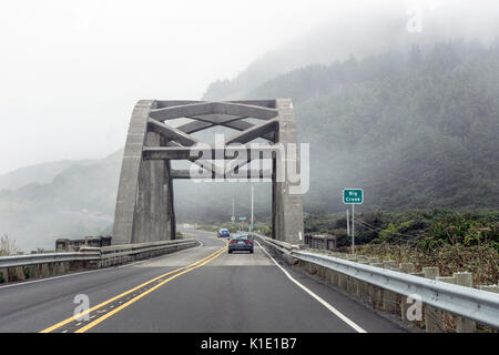 historic Big Creek concrete arch bridge with concrete louver sides looms out of misty morning on Oregon coast highway driving vicinity town of Yachats Stock Photo