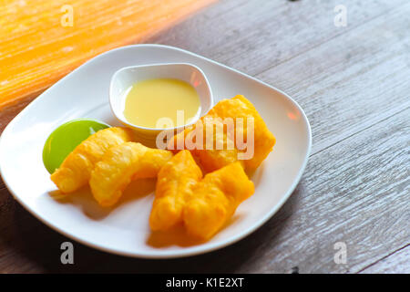 Youtiao with milk and coconut jam on morning table , best of thai breakfast Stock Photo