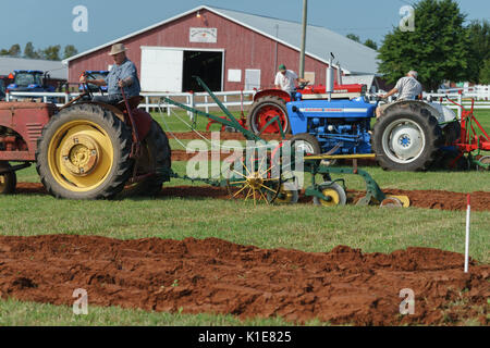 DUNDAS, PRINCE EDWARD ISLAND, CANADA - 25 Aug: Competitors plow with amtique tractors at the PEI Plowing Match and Agricultural fair on August 25, 201 Stock Photo