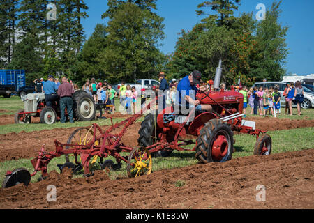 DUNDAS, PRINCE EDWARD ISLAND, CANADA - 25 Aug: Competitors plow with amtique tractors at the PEI Plowing Match and Agricultural fair on August 25, 201 Stock Photo