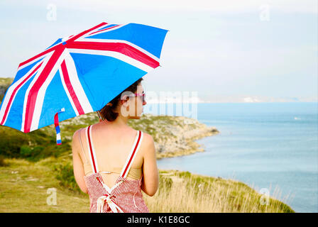 Portland Bill, Dorset, UK . 26th August 2017 - A young woman protects herself from the strong sun with her Union Jack sunshade Credit: stuart fretwell/Alamy Live News Stock Photo