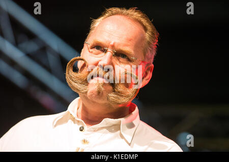 Stuttgart, Germany. 27th Aug, 2017. Thomas Klingenberg, participant of the Swabian Beard Championships for everyone presents his beard to the audience during the brewery festival of the brewery 'Stuttgarter Hofbräu' in Stuttgart, Germany, 27 August 2017. Photo: Christoph Schmidt/dpa/Alamy Live News Stock Photo