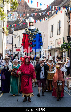 800th anniversary parade to celebrate the Battle of Sandwich of 1217. Procession of re-enactors dressed in medieval costume lead by man dressed in red robe. Large effigy of knight carried. Stock Photo