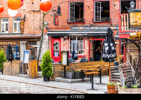 Quebec City, Canada - May 30, 2017: Lower old town cobblestone street called Sous le Fort with restaurants and hanging colorful decorations Stock Photo