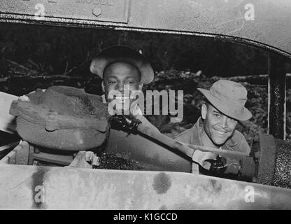 Two soldiers, Private James A Jackson of Kearneysville, West Virginia, and Private First Class Willie Lee Jell, of Baton Rouge, Louisiana, making repairs on a motor grader, 1942. From the New York Public Library. Stock Photo