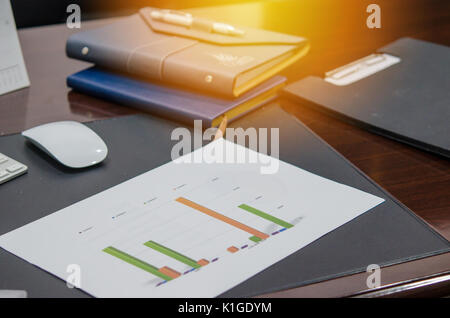 Documents, graphs and mouse Notebook on the desk Stock Photo