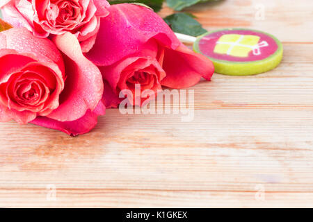 pink roses and sweets on table. copy space Stock Photo