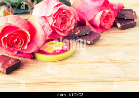pink roses and sweets on table. copy space Stock Photo