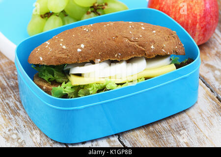 Healthy school lunch containing brown roll with cheese and hard boiled egg and fresh fruit Stock Photo