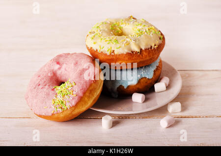 Donuts on a plate with marshmallow on a white wooden background Stock Photo