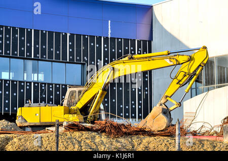 Excavator on a construction site. Yellow excavator at the construction of a new swimming pool in the city. Stock Photo