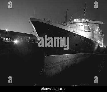 Night photograph of QE2 in the King George V dry dock at Southampton Docks, Southampton, Hampshire, England, where she is having helicopter landing pads fitted for service in the Falklands War - May 1982 Stock Photo