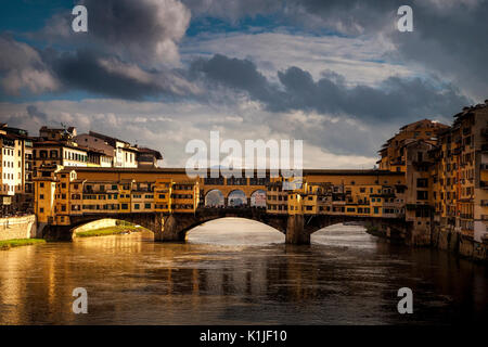 Warm evening light shines on the iconic Ponte Vecchio bridge in Florence, Italy. Stock Photo
