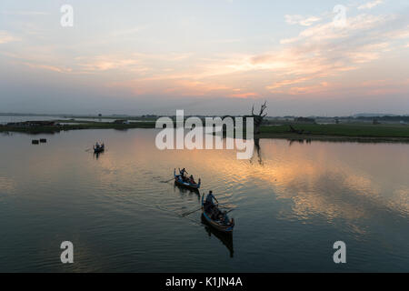 Tourists explore Lake Taungthaman on rowing boats near U Bein Bridge, Amarapura, Myanmar. Stock Photo