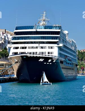 Azamara Journey R-class cruise ship with a small saling boat in Mahon Menorca Minorca Spain Stock Photo