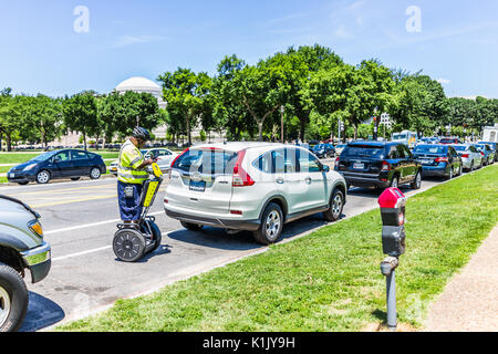 Washington DC, USA - July 3, 2017: Police traffic officer writing ticket for car illegally parked while riding segway on national mall Stock Photo