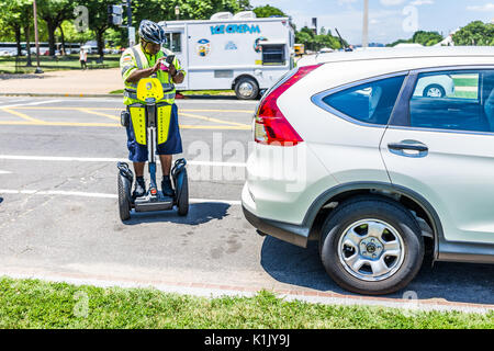 Washington DC, USA - July 3, 2017: Police traffic officer writing ticket for car illegally parked while riding segway on national mall Stock Photo