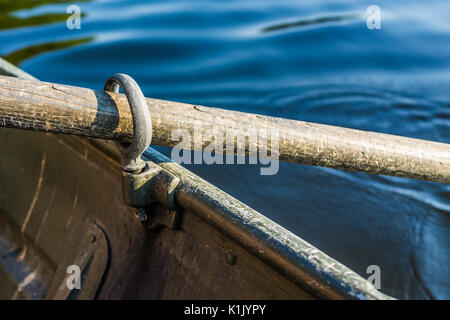 Row boat oar lock closeup in hole during summer with water Stock Photo