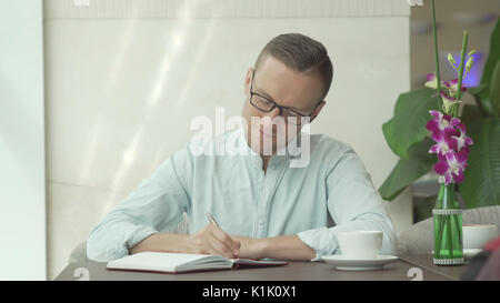 Businessman writing in the personal organizer Stock Photo