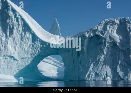 Greenland, Eastern Greenland, Scoresbysund aka Scoresby Sund, Bear Island aka Bjorne Oer. Huge iceberg with hole around the Bear Islands. Stock Photo