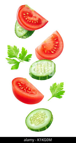 Isolated vegetables. Mixed slices of cucumber and tomato in the air isolated on white with clipping path Stock Photo