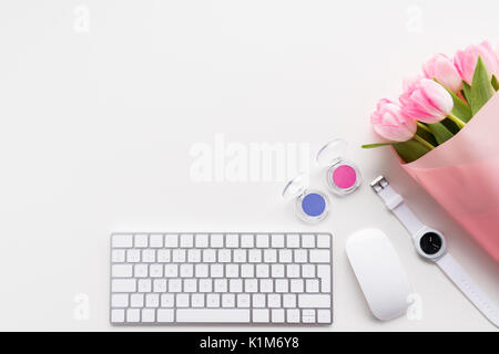 Flat lay of beautiful bouquet of pink tulips, keyboard and computer mouse isolated on white Stock Photo