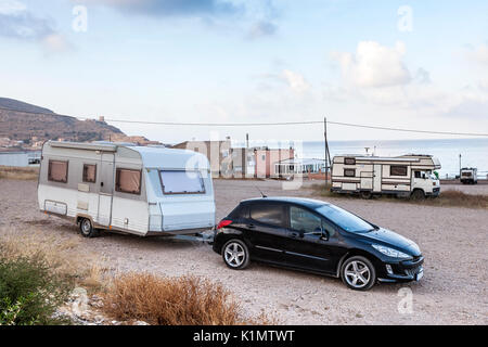 Car with a caravan on a parking lot at the mediterranean coast in Murcia, Spain Stock Photo